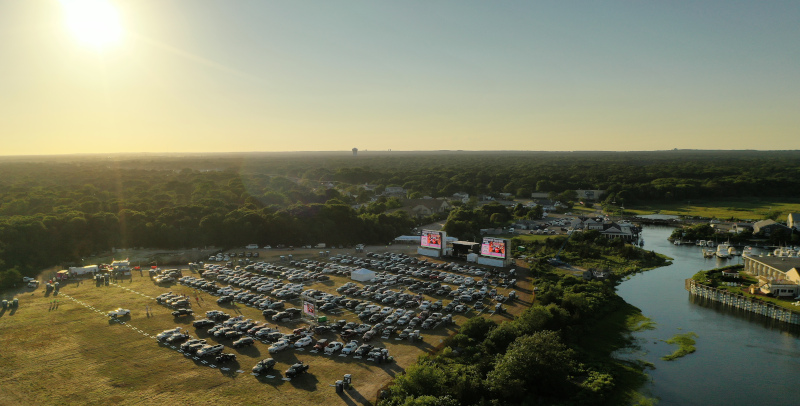 Yarmouth, Massachusetts Drive In aerial view of cars parked on the grass at a drive in theatre along a river